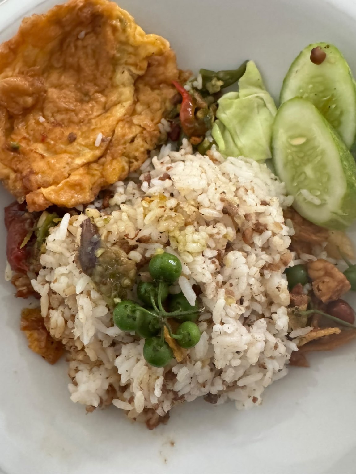 Sepiring nasi tutug oncom dengan telur dadar, leunca, tempe, mentimun, kol, dan sambal